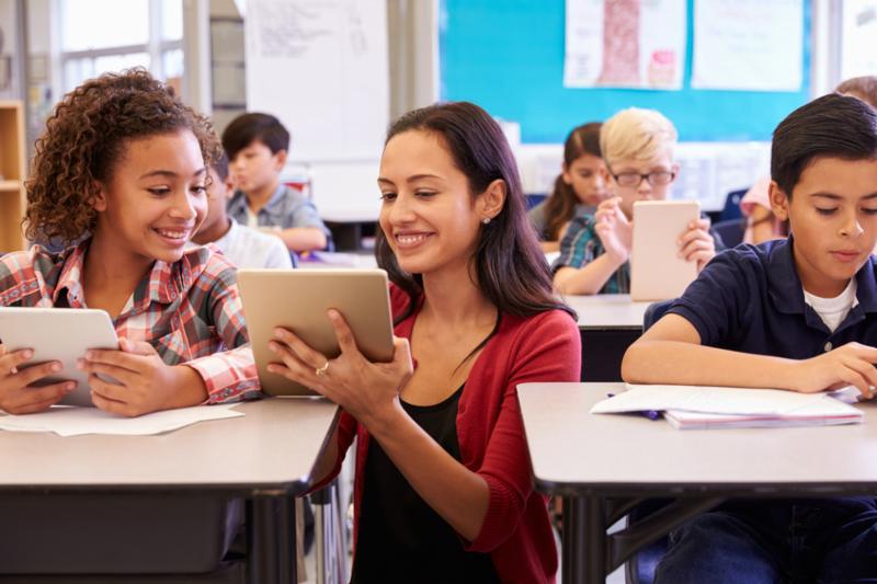 Teacher-helping-kids-with-computers-in-elementary-school-000088473777_Small